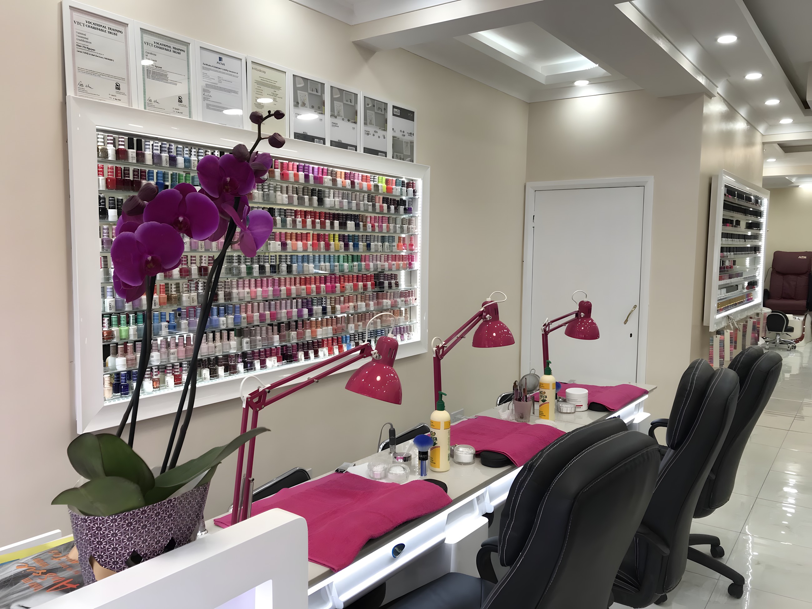 Inside Extreme Nails: pink manicure stations, an orchid and a wall of polish colours